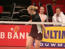 Anu Nieminen smiling and returning a badminton birdie.